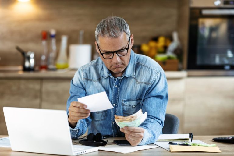 Man looking at papers sitting at a desk.